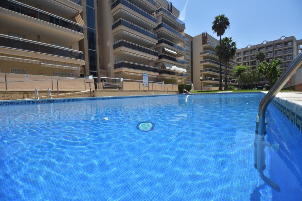 Una piscina vacía frente a edificios de apartamentos. en Ventura Park 1 6, en Salou