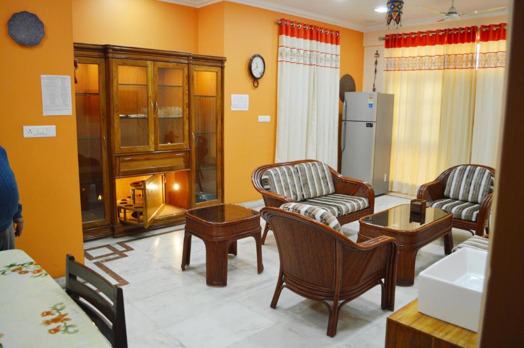 a living room with chairs and a table at Fully Furnished ISH, Atithya Homestay with various amenities and free services in Lucknow, INDIA in Lucknow