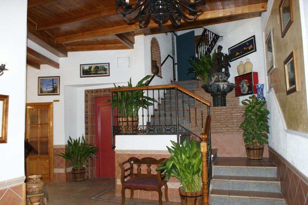 a living room with a staircase with potted plants at Hotel Juan Francisco in Güéjar-Sierra