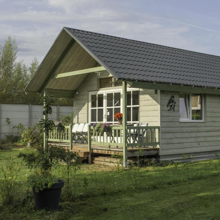 a small house with a porch and a fence at de Bosuil in Steensel