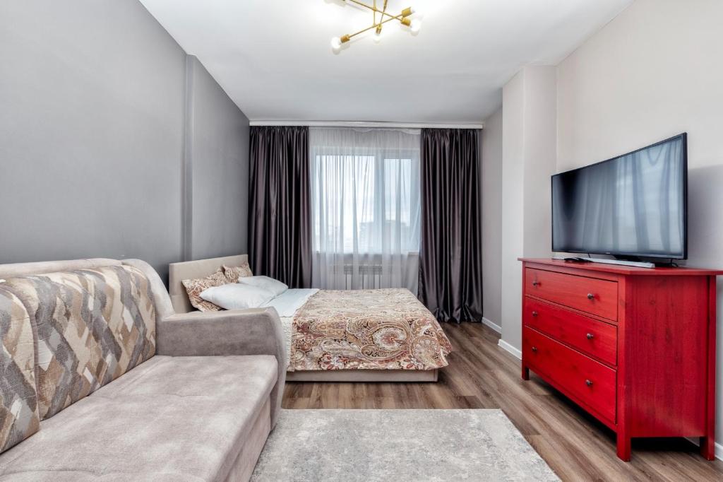 un soggiorno con divano e TV a schermo piatto di Уютные апартаменты в Астане a Astana