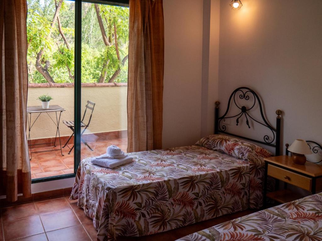 Un dormitorio con una cama y un balcón. en El Cerrao-PauNatura, en Sot de Chera