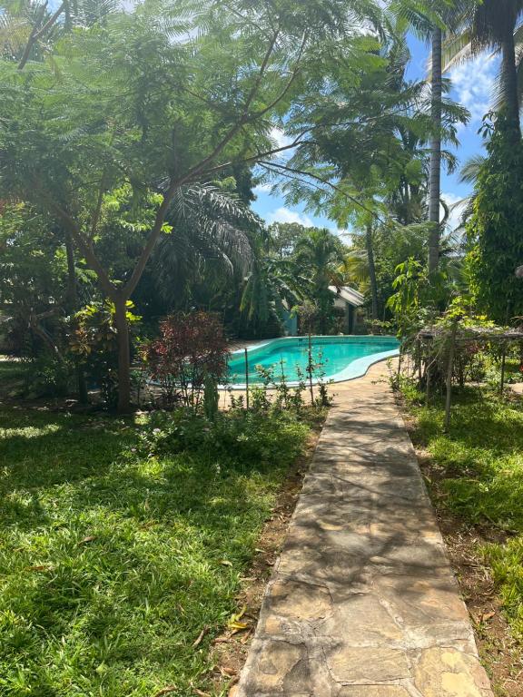 a path leading to a swimming pool at a resort at Villa vanessa in Malindi