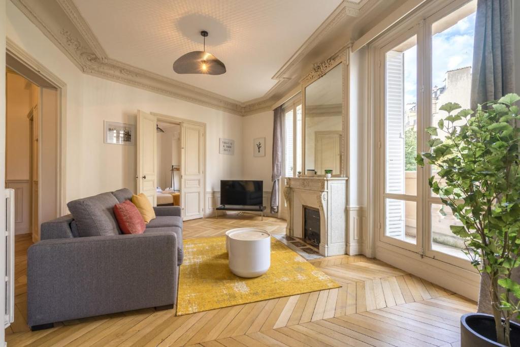 un salon avec un canapé et une cheminée dans l'établissement Apartment 3BR - 10P - Passy - Eiffel Tower, à Paris