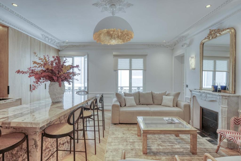 un salon avec un canapé et une table dans l'établissement Appartement Montaigne Luxury, à Paris