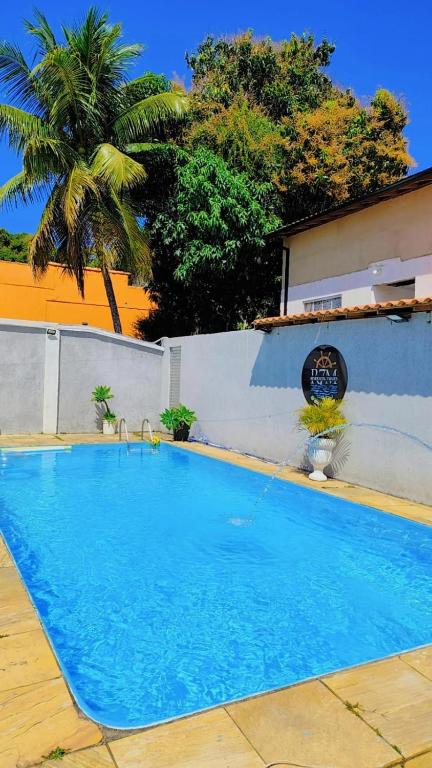 a large blue swimming pool next to a building at Residencial 7 Mares in Rio das Ostras