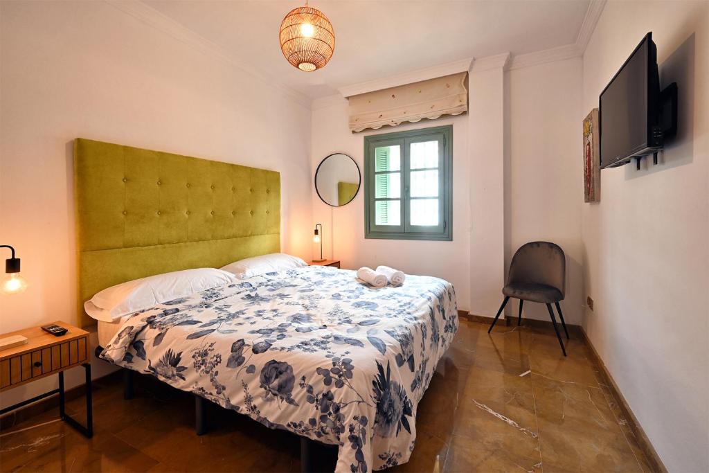 Villa Arte de Aguilas في El Palo: غرفة نوم بسرير على اللوح الاخضر وتلفزيون