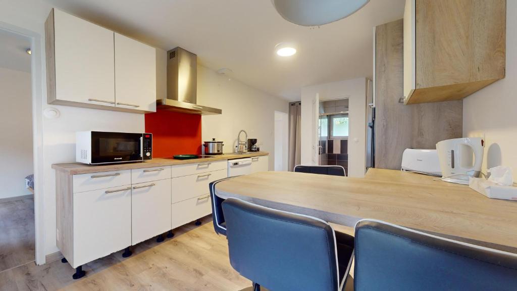 une cuisine avec une table en bois et des chaises bleues dans l'établissement Evasion Nature Rimbach, à Rimbach-près-Masevaux