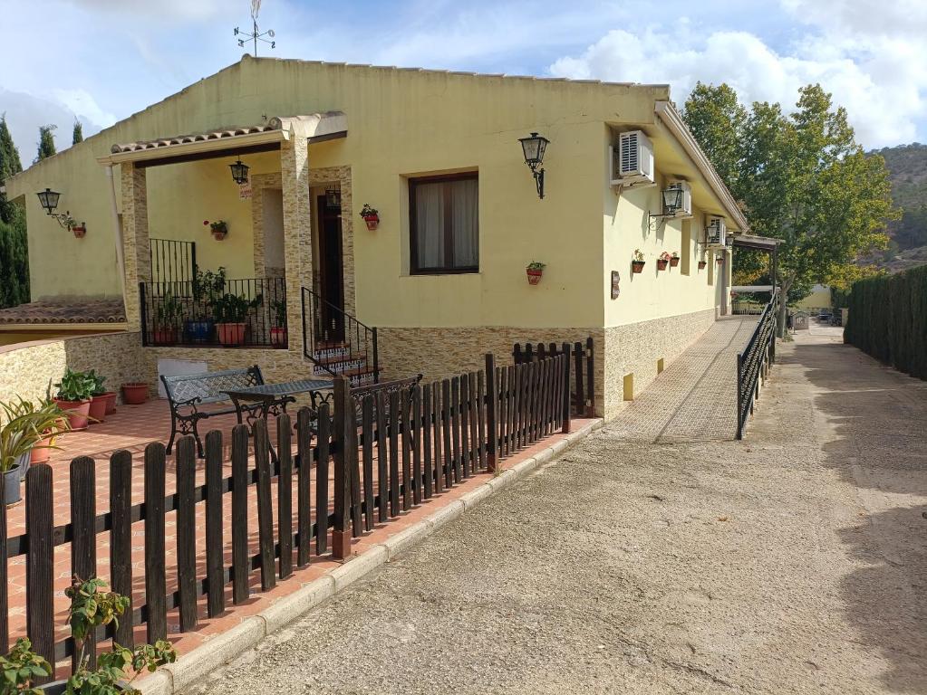 a house with a fence in front of it at Chalet con piscina in Pinoso