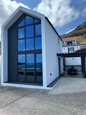 a building with a large window on a patio at Casa dos Anjos in Vila do Porto
