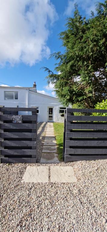 a fence in front of a white house at Cottage in Newquay
