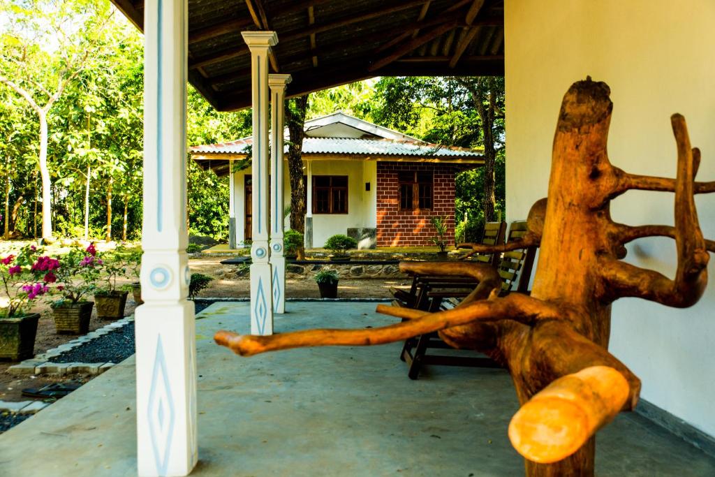 a wooden sculpture of a dog on a porch at Sunshadow Chalet in Tangalle