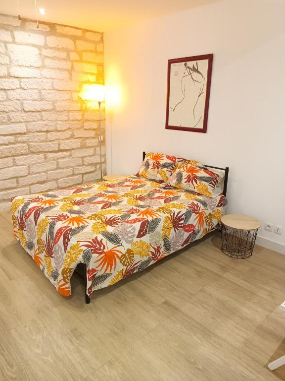 une chambre avec un lit et un mur de briques dans l'établissement Lumineux appartement climatisé, à Montpellier