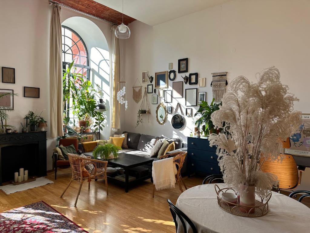a living room with a couch and a table at Studio Włókno - słoneczny loft u Scheiblera in Łódź