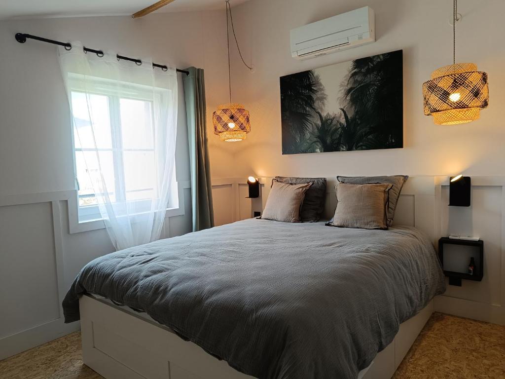 a bedroom with a large bed and a window at Loft des Voyageurs - Parking Inclus in Manosque