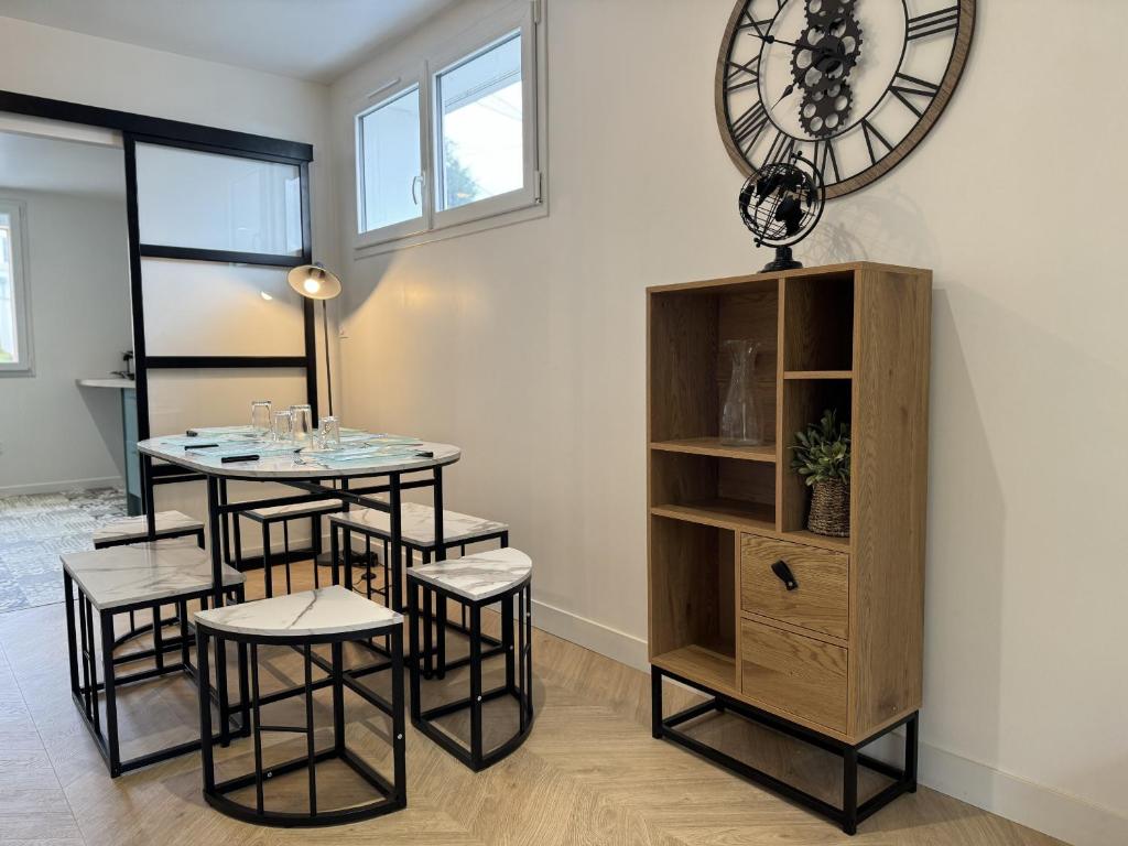 une salle à manger avec une table, des chaises et une horloge dans l'établissement LOasis - Gazonfier - 7 pers - Rêve au Mans, au Mans