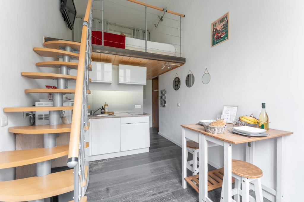 une cuisine et une mezzanine avec un escalier et une table dans l'établissement Silk - Studio en plein coeur de Lyon, à Lyon