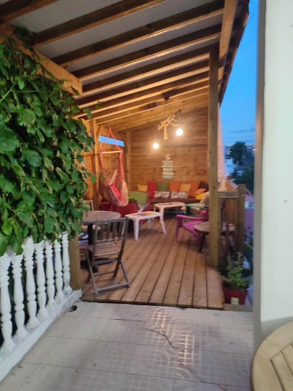 a wooden deck with a table and chairs on it at La passiflore in Le Gosier