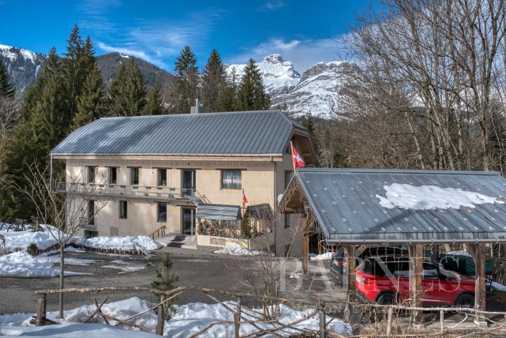 a house with a red van parked in front of it at Le Moulin des Olirics in Sallanches