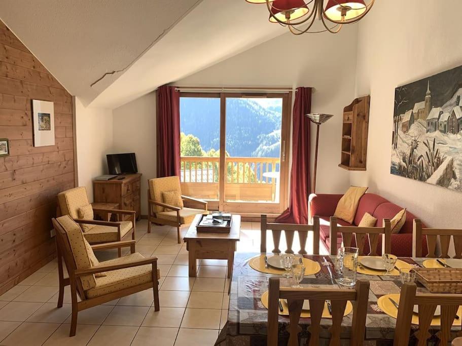 un salon avec des tables et des chaises et une grande fenêtre dans l'établissement Paradiski proche des pistes plan peisey, à Peisey-Nancroix