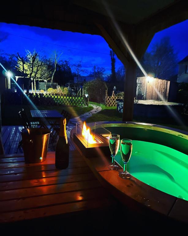 - deux verres de vin assis sur une table à côté d'une piscine dans l'établissement Côté Jardin, à Bobital