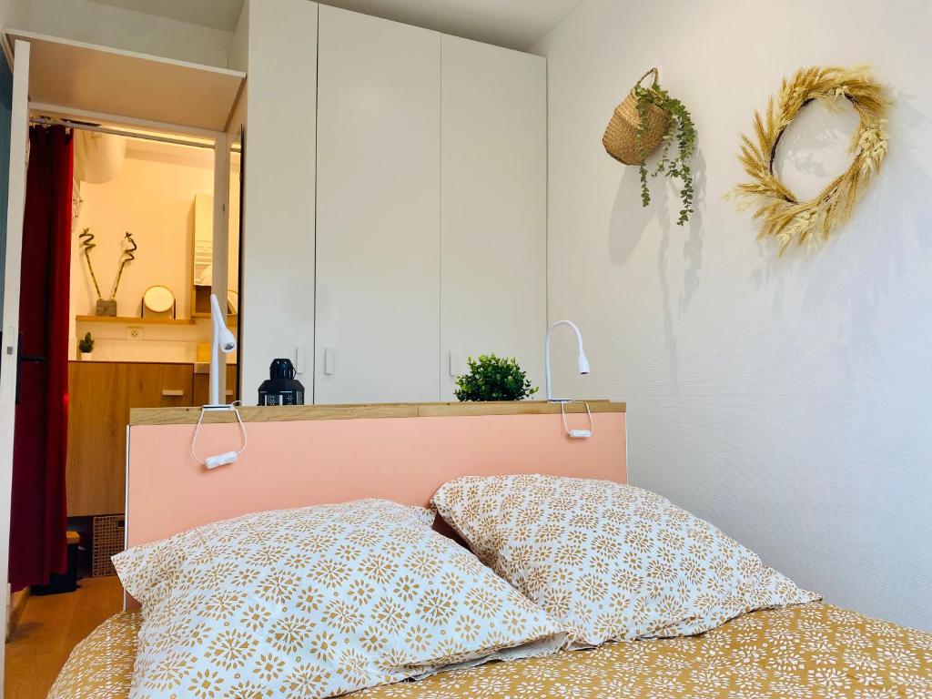 1 dormitorio con 1 cama rosa y 2 almohadas en Cocon des Champs-Élysées, en París