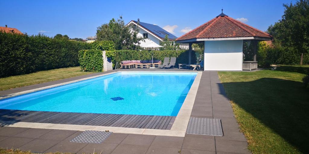 a swimming pool in a yard with a gazebo at Land Luxury in Seftigen