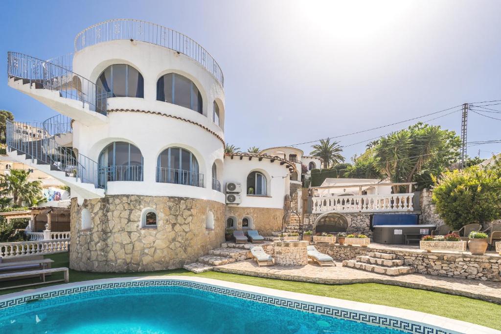 ein großes weißes Haus mit einem Pool davor in der Unterkunft Beautiful Casa au Lilas Rosa, Benissa Costa in Benissa