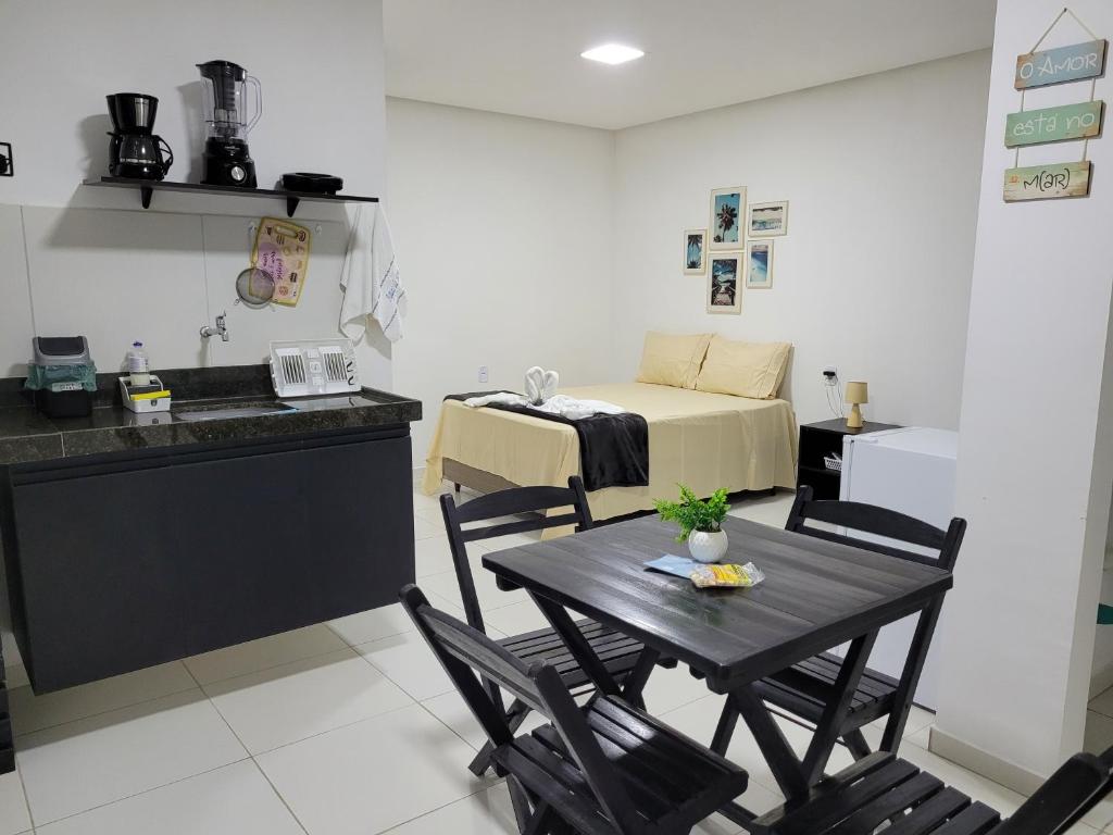 eine Küche mit einem Tisch und einem Bett in einem Zimmer in der Unterkunft Águas da Barra in Maragogi