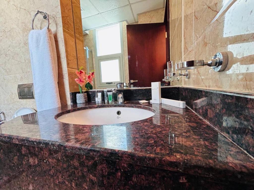 a bathroom with a sink and a large mirror at Aspire TowerTwo Bedroom Pilot Paradise in Manama