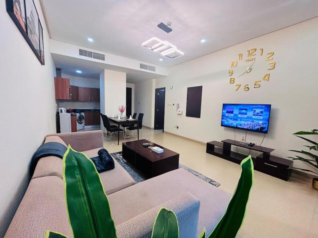 a living room with a couch and a tv and a table at Aspire Tower-One Bedroom Sunny Solo Stay in Manama