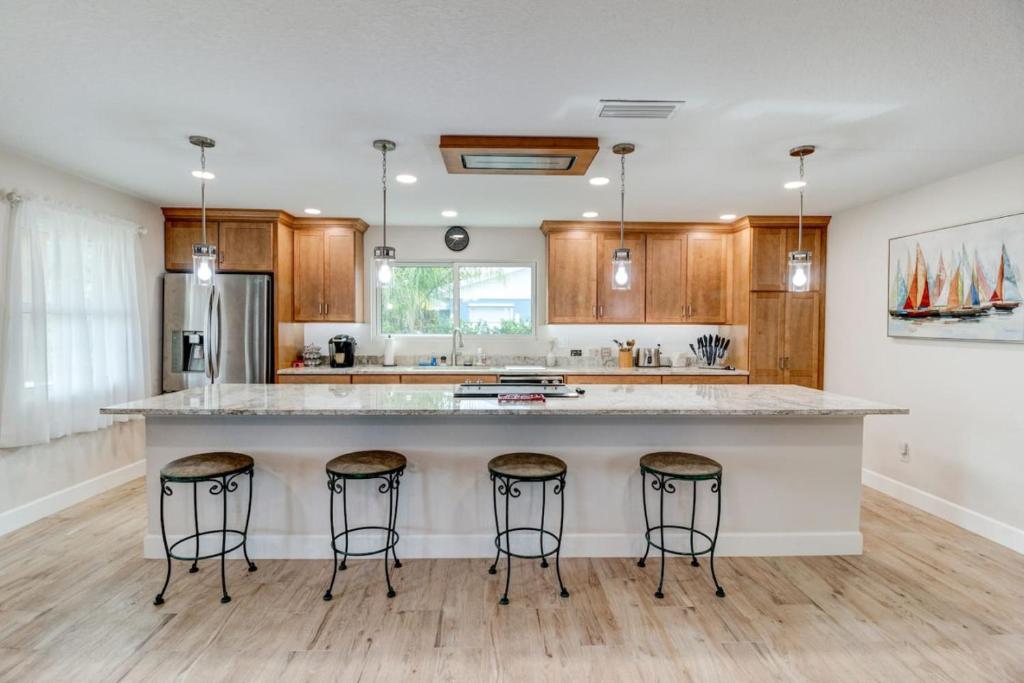 a kitchen with a large island with bar stools at Cape Key Updated Beach Bungalow in Port Orange