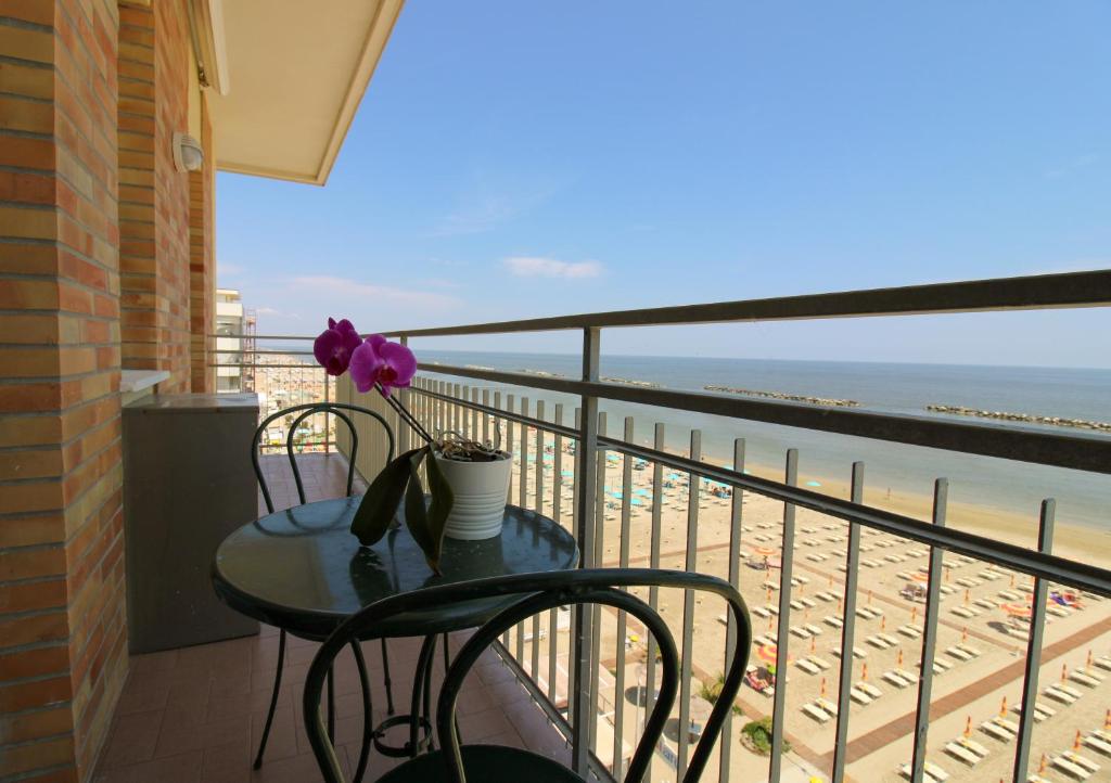a table and chairs on a balcony with a view of the beach at 14 Trilocale fronte mare Evangelisti Casa in Bellaria-Igea Marina