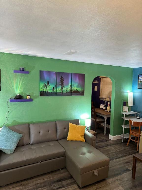 a living room with a couch and a green wall at Afternoon checkout in Moorhead