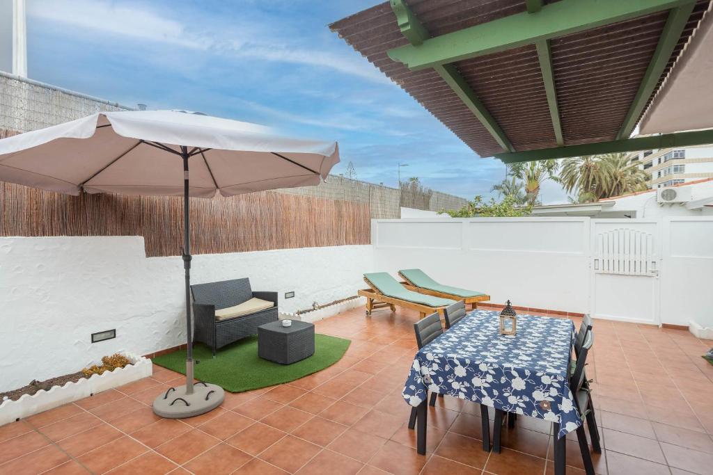 a patio with an umbrella and a table and chairs at Private Chill-out Terrace Bungalow - Pool in San Bartolomé de Tirajana