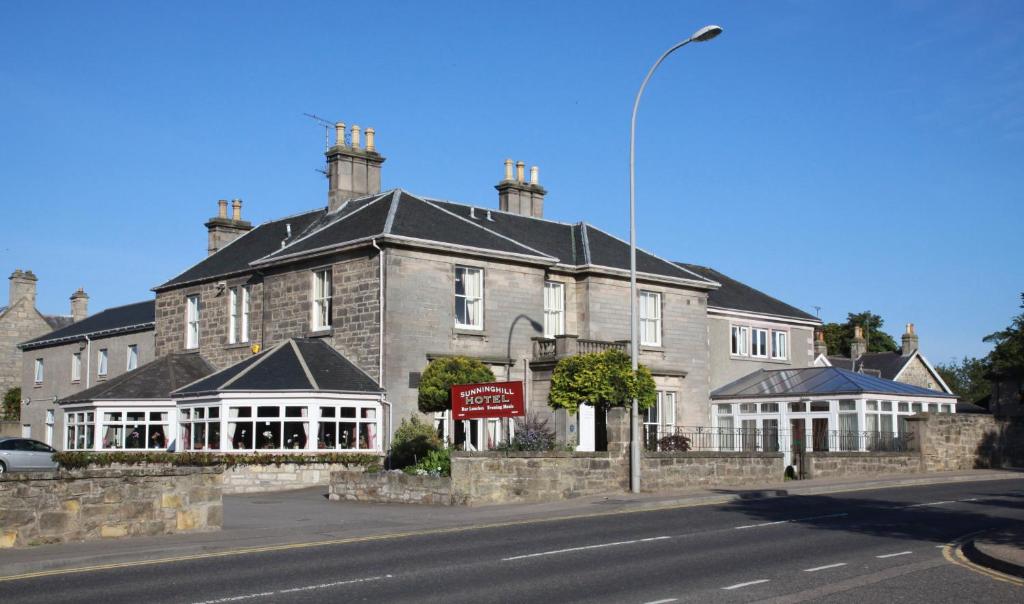 a house with a clock on the front of it at Sunninghill Hotel in Elgin