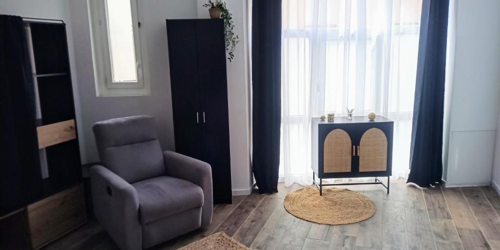 a living room with a chair and a table at La Pierre 2 studio entier in Tartas