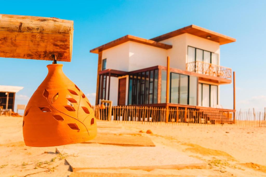 a house on the beach with a vase in front of it at Vila Cangalha in Camocim