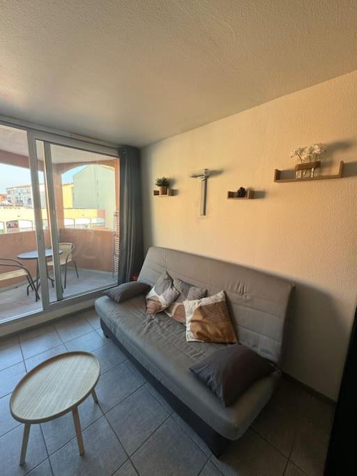 un salon avec un canapé et une table dans l'établissement Appartement - Cap d'Agde, au Cap d'Agde
