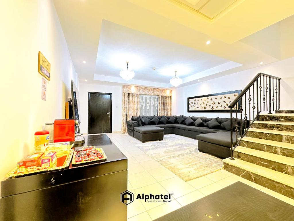 ein Wohnzimmer mit einer Couch und einem Tisch in der Unterkunft Stylish 3-bedroom plus Maid room - Villa in JVC - Dubai in Dubai