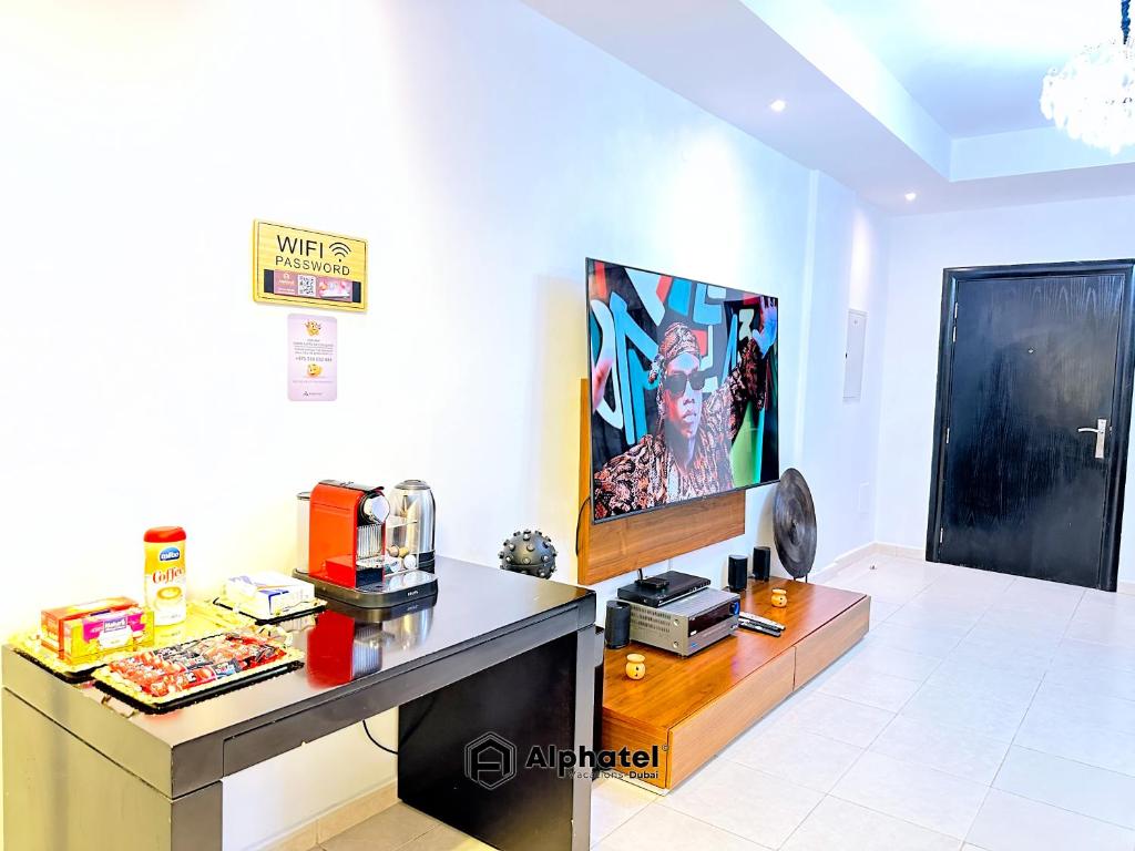 ein Wohnzimmer mit einem Schreibtisch und einem TV in der Unterkunft Stylish 3-bedroom plus Maid room - Villa in JVC - Dubai in Dubai