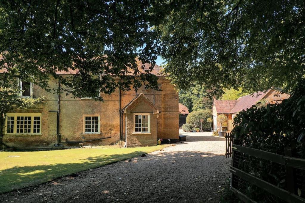 an old brick house with a fence in front of it at Landford's Cottage, your retreat! in Landford