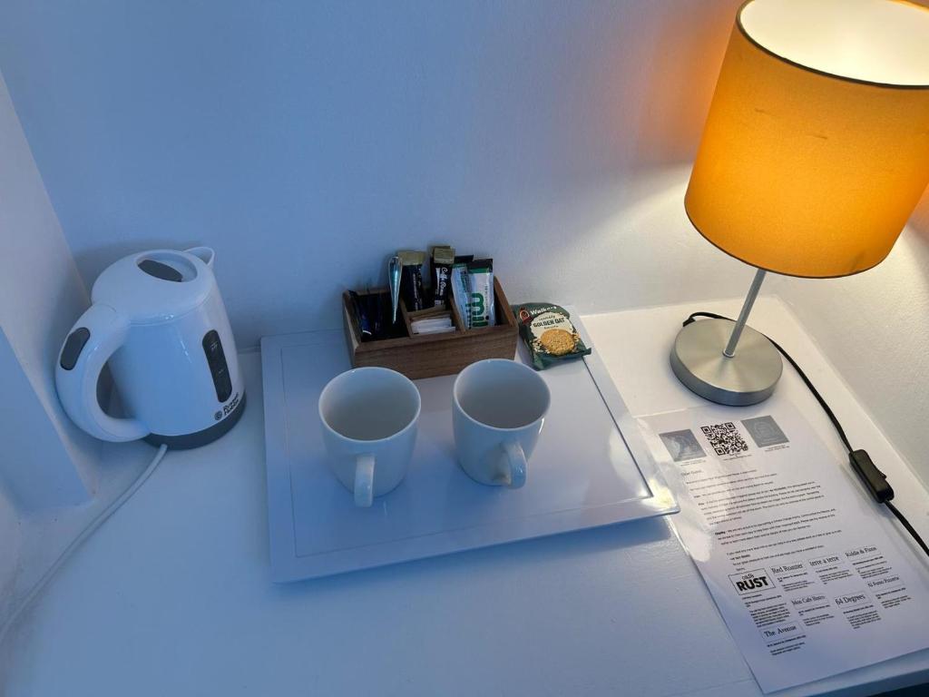 a desk with two mugs on a table with a lamp at Upper Rock Brighton – Guest House in Brighton & Hove
