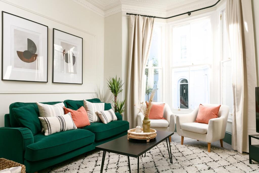 a living room with a green couch and two chairs at NEW LUXURY for 2024 - Central Plymouth House - Sleeps 10 - Access to Plymouth Town - Close to The Barbican - Pets welcome - Parking Available - By Luxe Living by Sophia in Plymouth