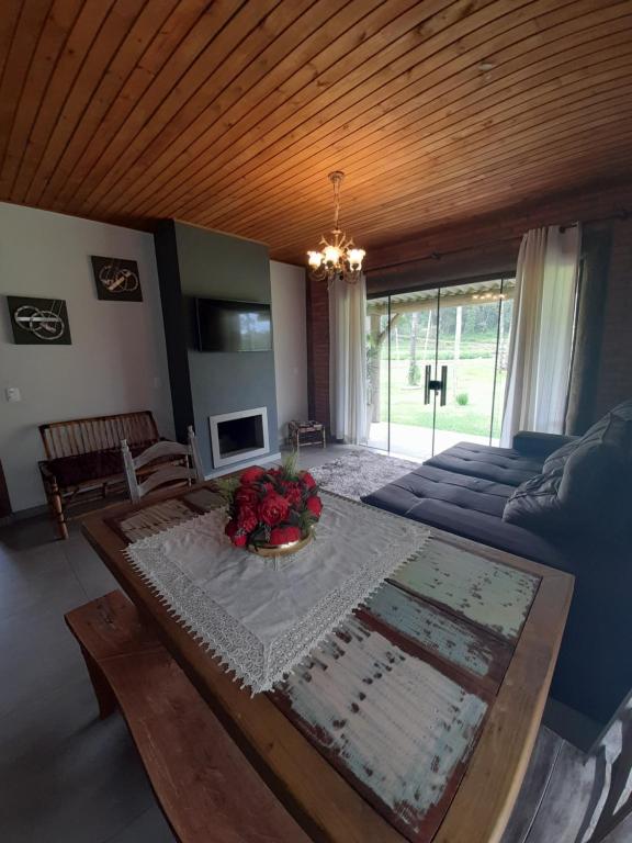 una sala de estar con una mesa y un sofá en Refúgio Altos do Campestre - TURISMO RURAL, en Urubici
