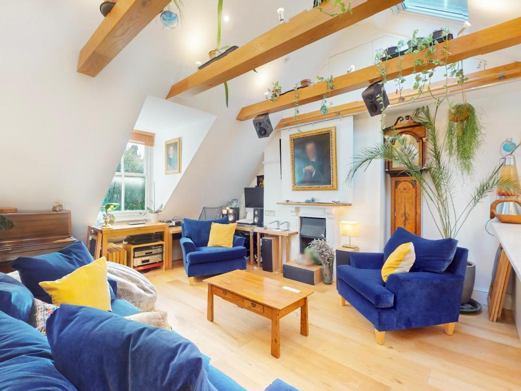a living room with blue couches and a fireplace at Pass the Keys Elegant flat in trendy Hampstead in London