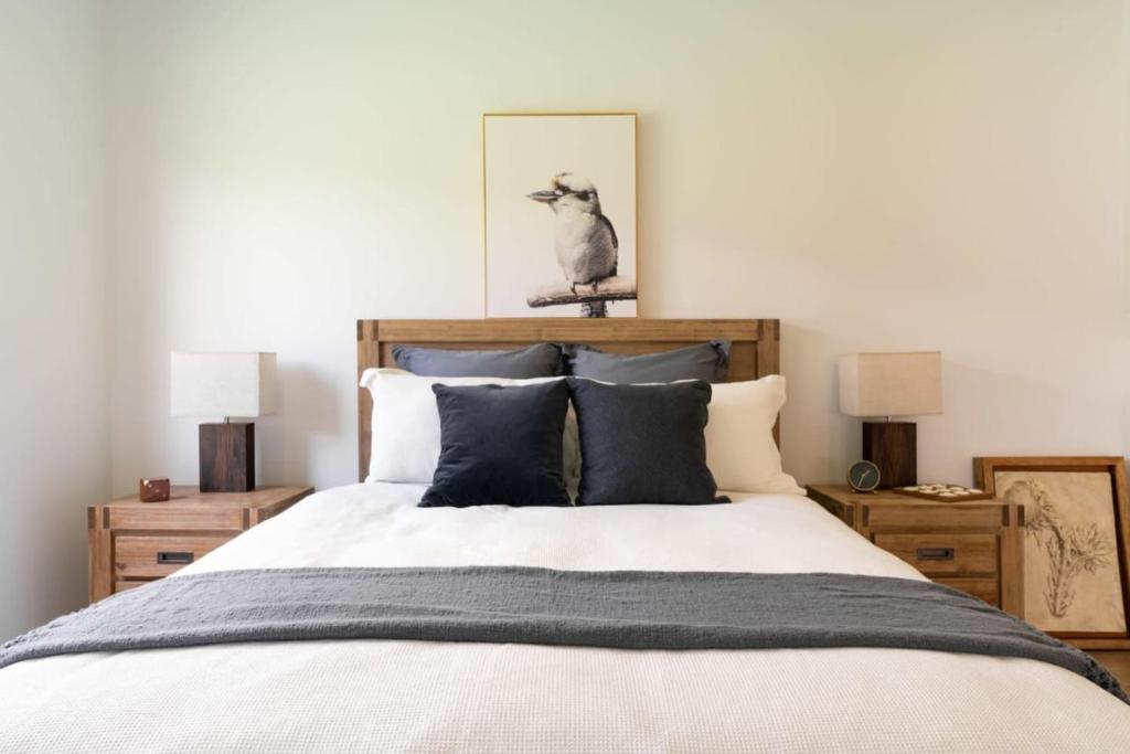 a bedroom with a bed with pillows and a bird on top of it at New Designer Built Boutique Holiday Home Heathwood in Doolandella