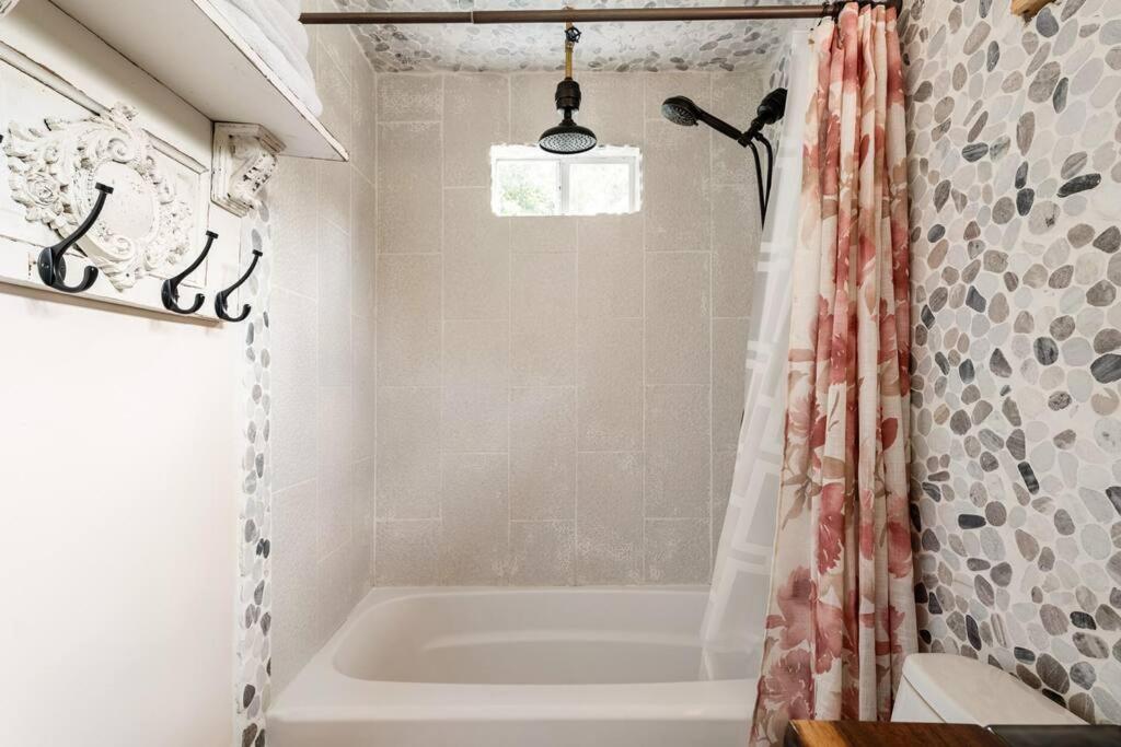 ein Badezimmer mit Badewanne und Duschvorhang in der Unterkunft Cozy Coop Casita - Lake Travis-Hot Tub-Tiny House in Austin