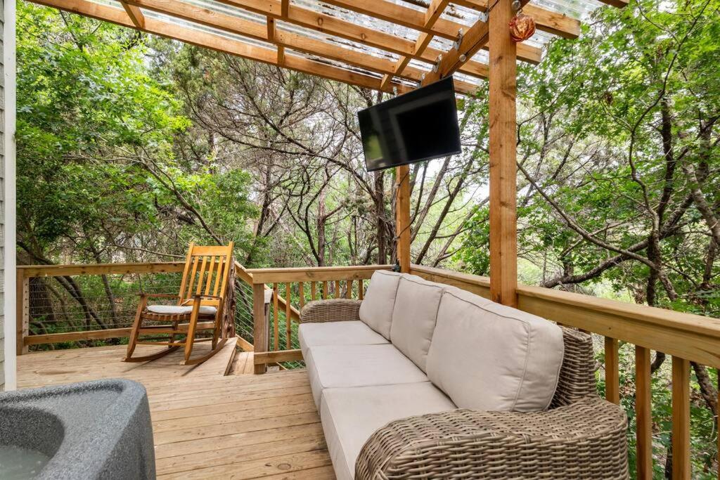 eine Veranda mit einem Sofa und einem TV auf einer Terrasse in der Unterkunft Cozy Coop Casita - Lake Travis-Hot Tub-Tiny House in Austin