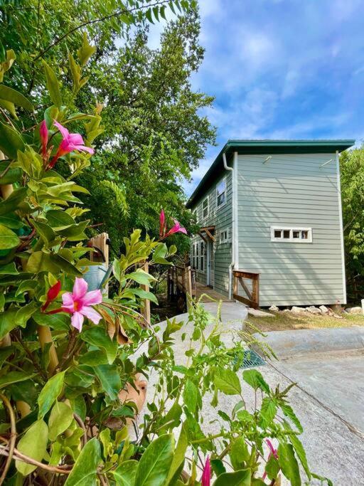 ein Haus mit einem Gebäude und Blumen davor in der Unterkunft Cozy Coop Casita - Lake Travis-Hot Tub-Tiny House in Austin